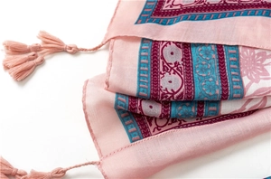 Close-up of pink cotton blend scarf featuring ethnic floral print and handmade tassels
