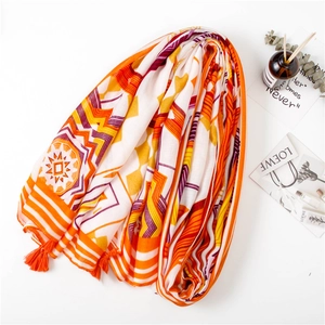 Close-up of geometric pattern scarf with orange fringe and breathable linen texture