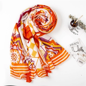 Macro view of geometric ethnic patterns and orange fringe tassels on cotton linen scarf