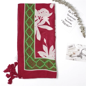 Floral viscose beach shawl with red tassels and green geometric patterns on a white base
