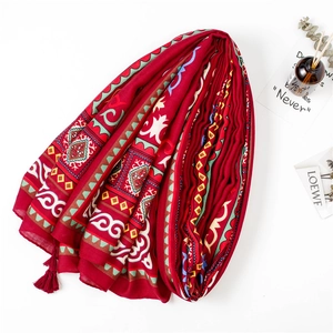 Écharpe rouge style ethnique bohème avec détails de pompons sur fond blanc