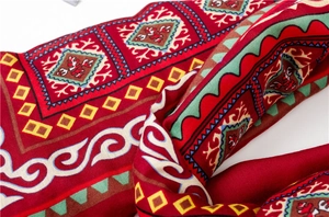 Gros plan d'un châle en tricot rouge avec motifs ethniques et détails de rennes