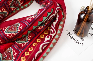 Gros plan détaillé de l'écharpe à motif ethnique rouge et texture de tissu doux