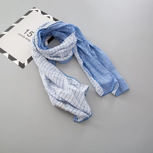 Détail de l'écharpe en coton à rayures bleues et blanches avec bordure bleue cousue