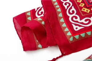 Détail des motifs ethniques et des franges sur un châle d'été rouge élégant