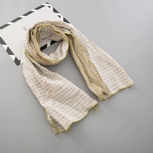 Détail d'une écharpe en coton à rayures avec des bords surjetés jaune-vert pour enfants