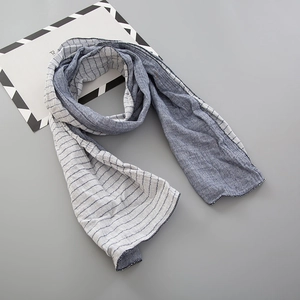 Détail d'une écharpe en coton à rayures bleu-gris montrant les coutures et la texture