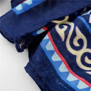 Détail du châle en coton bleu avec imprimés ethniques et pompons tissés décoratifs