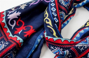 Détail d'une écharpe bleu marine à motifs tribaux montrant les imprimés et les plis du tissu