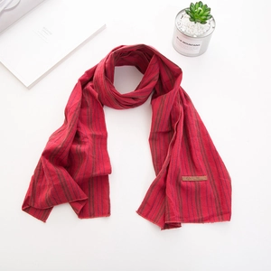 Détail de l'écharpe pour enfants en coton rayé rouge avec étiquette en cuir