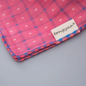 Macro detail of pink cotton linen fabric with blue plaid and polka dot patterns