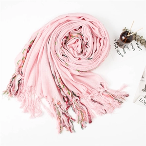 Detail of pink cotton linen scarf with colorful embroidered ethnic stripes and tassels