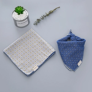 Close-up of cotton gauze baby bibs with plaid patterns and blue woven edge trim