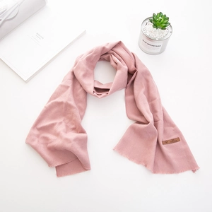 Sciarpa rosa per bambini in finto cashmere con frange ed etichetta in pelle su bianco