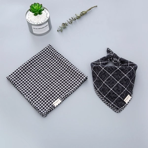 Detailed view of black and white gingham and windowpane cotton scarves for babies