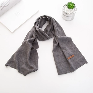Dettaglio sciarpa per bambini grigio scuro con etichetta logo in pelle e maglia morbida