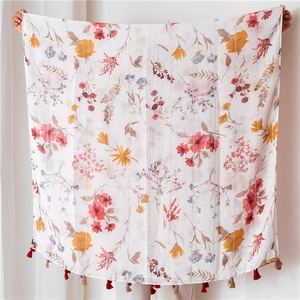 Detail of floral linen shawl featuring silver glitter stripes and colorful fringe tassels
