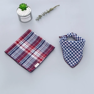 Detail of checkered cotton scarves featuring meticulous lockstitch edges and woven labels