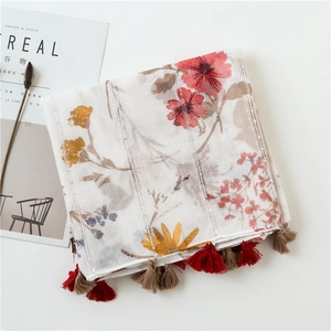 Detail of floral linen scarf with metallic thread, fringe edges and stylish prop layout