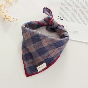 Close-up of retro plaid cotton linen scarf with red overlock stitching and woven label