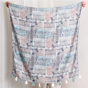 Detail of bohemian cotton linen shawl featuring paisley patterns and long tassel fringe