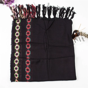 Detail of black cotton linen scarf featuring colorful geometric chain patterns and tassels