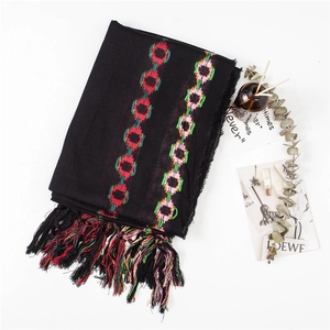 Close-up of black cotton-linen scarf featuring colorful geometric circles and hand-woven tassels