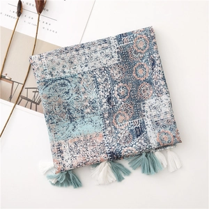 Detail of bohemian print scarf featuring mandala patterns and cotton tassel fringe