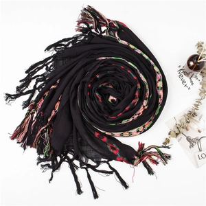 Detail of black cotton linen scarf showing colorful geometric weaving and long tassels