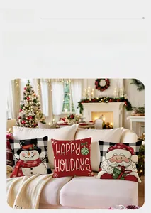 Détail de housses de coussin de Noël avec motifs Père Noël et bonhomme de neige