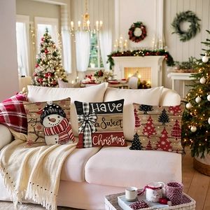 Three-piece Christmas pillow covers set with snowman and festive tree on a white sofa