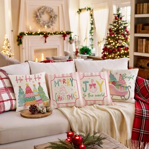 Set of 4 Christmas throw pillow covers with festive holiday prints on a white sofa