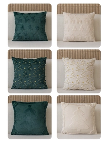 Détails des motifs de rennes et de sapins de Noël sur des coussins en peluche touffetés