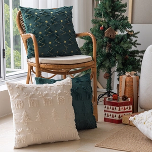 Housses de coussin de Noël avec broderies d'arbres verts et motifs de rennes sur une chaise