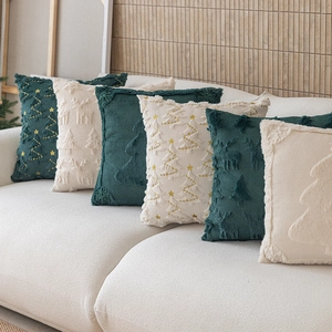 Coussins de Noël avec motifs brodés de renne et sapin sur canapé décoratif