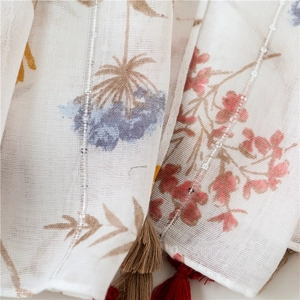Detail of floral chiffon scarf with sheer mesh texture, beads and fringe trim