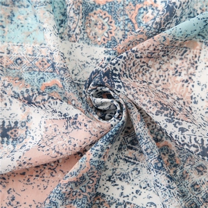Close-up of soft bohemian paisley print fabric with blue and orange fringe details