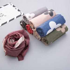 Detailed texture of soft cashmere-like knit scarf with vibrant floral patterns