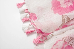 Vue détaillée de l'imprimé floral rose sur écharpe légère en coton-lin avec bords à franges