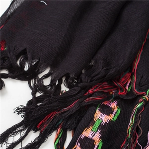Close-up of black cotton linen scarf with colorful chain embroidery and fringe details