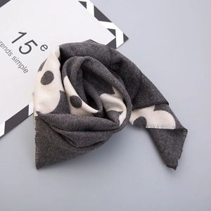 Close-up of thick knit scarf featuring fringe details and minimalist pattern