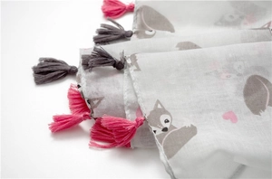 Macro detail of scarf featuring cartoon fox print and decorative colorful fringe tassels