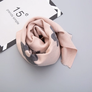 Close-up of soft pink and grey cashmere-like scarf with fringe edges and rose styling