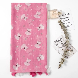 Pink scarf with cat print and tassels on a white background with decorative props