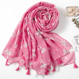 Close-up of pink scarf featuring cute cat prints, heart patterns and fringe edges