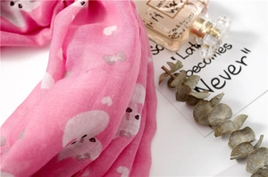 Detail of pink scarf with white cartoon animal patterns and heart-shaped prints