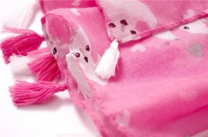 Detail shot of pink scarf showing cute fox heart print and handmade fringe tassels