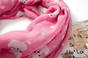 Detail of soft pink scarf showing delicate fabric texture and cute cartoon cat prints