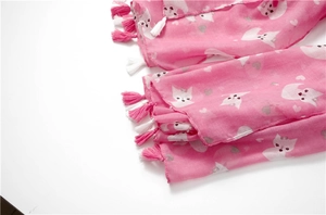 Detail of pink scarf with cute white fox print and decorative soft fringe tassels
