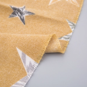 Vue macro de l'écharpe jaune moutarde à motif d'étoiles avec bords à franges